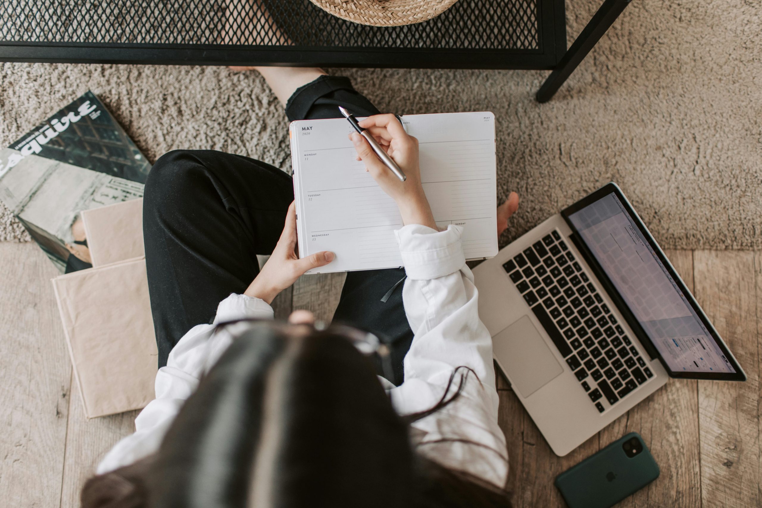 female student writing an essay infront of laptop